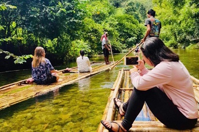 Two rafts floating gently down a shallow river