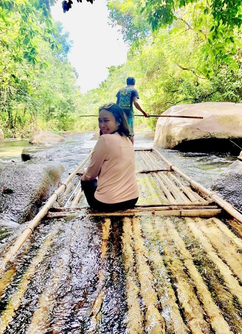 A woman enjoying a relaxing ride on a bamboo raft in Phang Nga