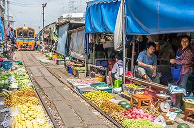 Vendors at their stalls waiting for the train to pass at Maeklong railway market